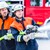 Zwei Feuerwehrmänner beim Löschen halten Wasserschlauch